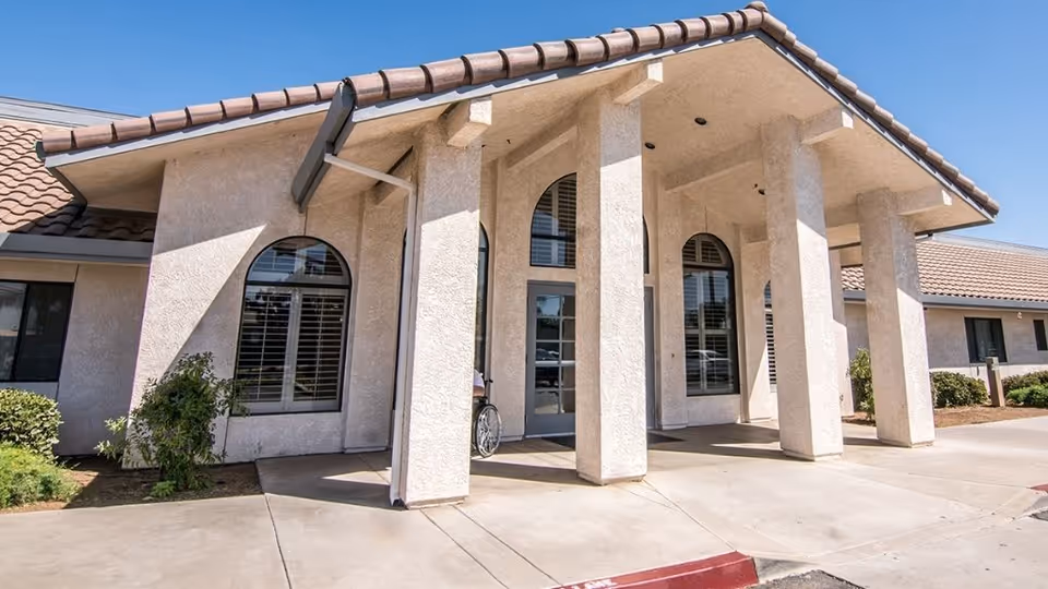 The entrance of Lindsay Gardens Nursing & Rehabilitation, featuring a covered porch and large windows.
