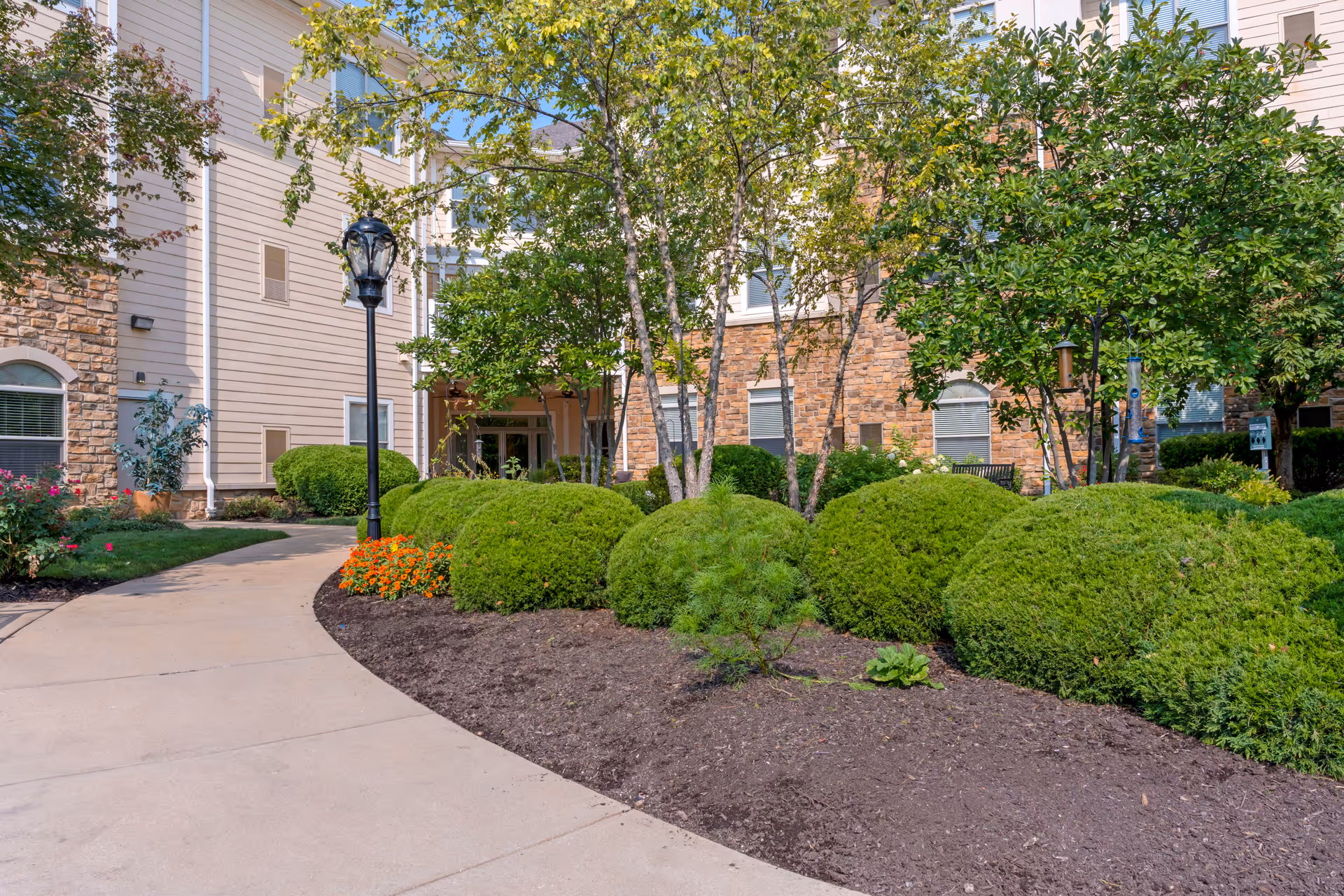 Exterior view of Brookdale West County entrance with walkway and manicured shrubs.