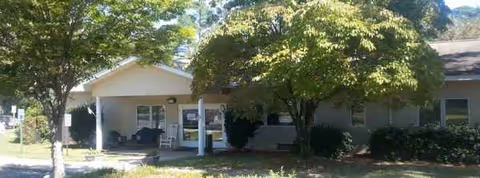 Exterior of Sedgewood Manor Healthcare Center with a covered entrance and trees.