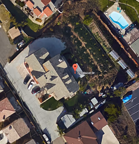 Aerial view of a house, driveway, and neighboring yards with a red map pin labeled '727 Ascot Dr'.