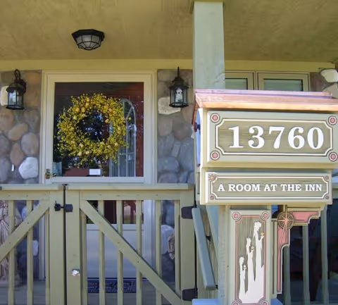 Front porch of A Room at the Inn, showing address plaque and wreath.