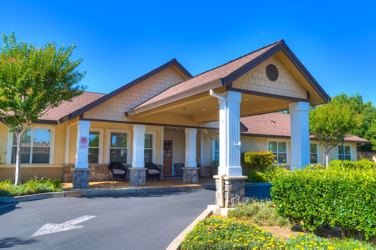 Front entrance of The Meadows Senior Living with columns and landscaping.