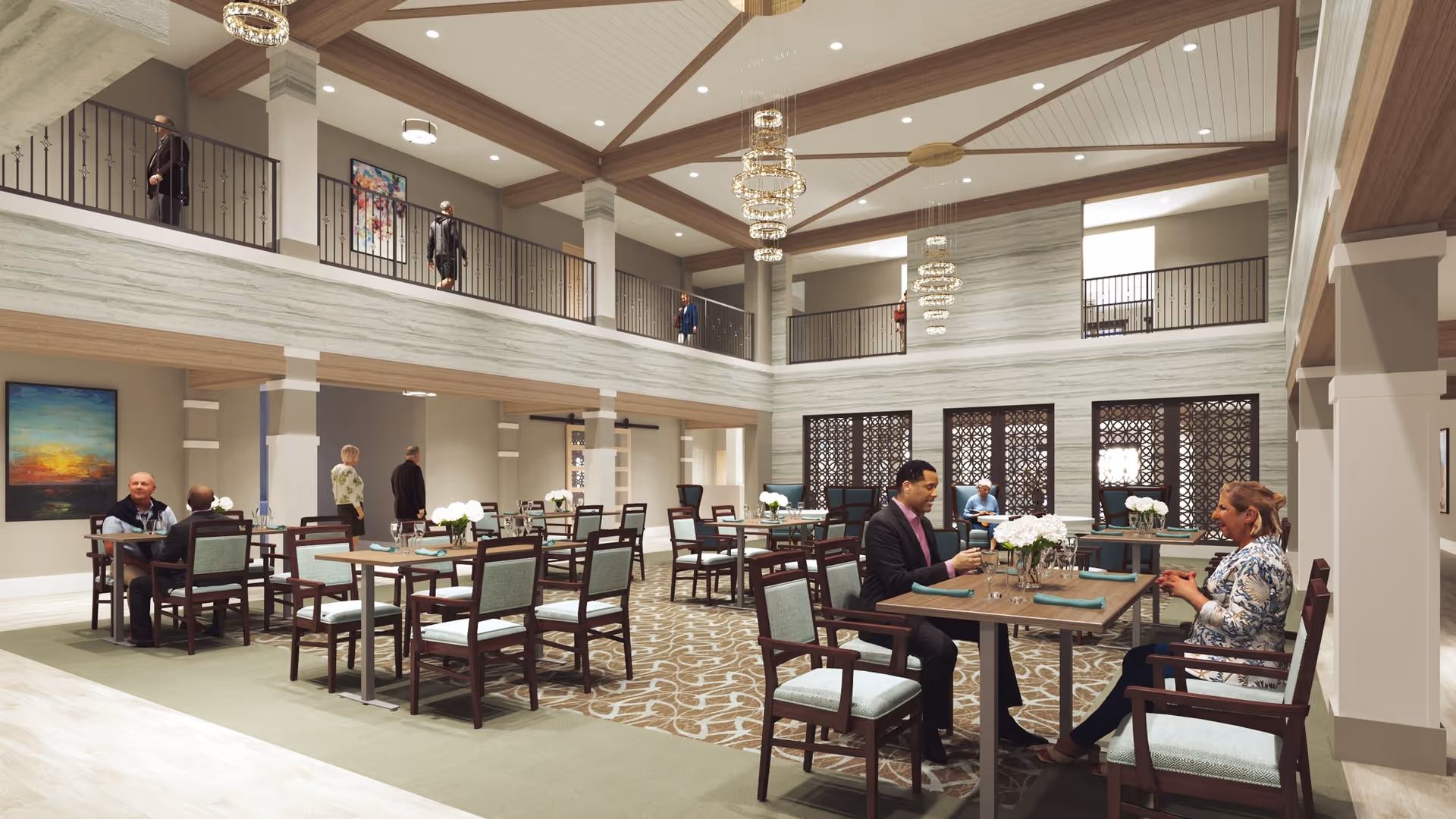 A spacious, well-lit dining area in a senior living facility with multiple tables and chairs arranged neatly. Several people are seated and conversing at the tables. The room features high ceilings with wooden beams, modern chandeliers, and a second-floor balcony overlooking the dining space. The walls are decorated with artwork and large windows with decorative screens.