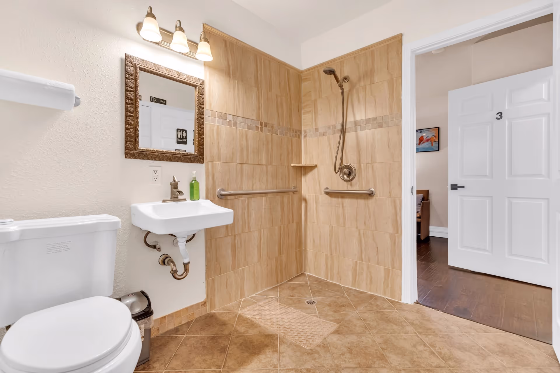 Accessible bathroom with a walk-in tiled shower, wall-mounted sink, toilet, grab bars, and an open door to a room labeled '3'.