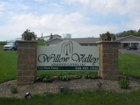 Willow Valley Assisted Living sign with brick pillars and manicured landscaping.