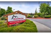 Entrance sign reading 'Mountain Glen Retirement and Assisted Living' beside a landscaped driveway with the facility building in the background.