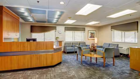 Lobby with a curved wood reception desk and a seating area.