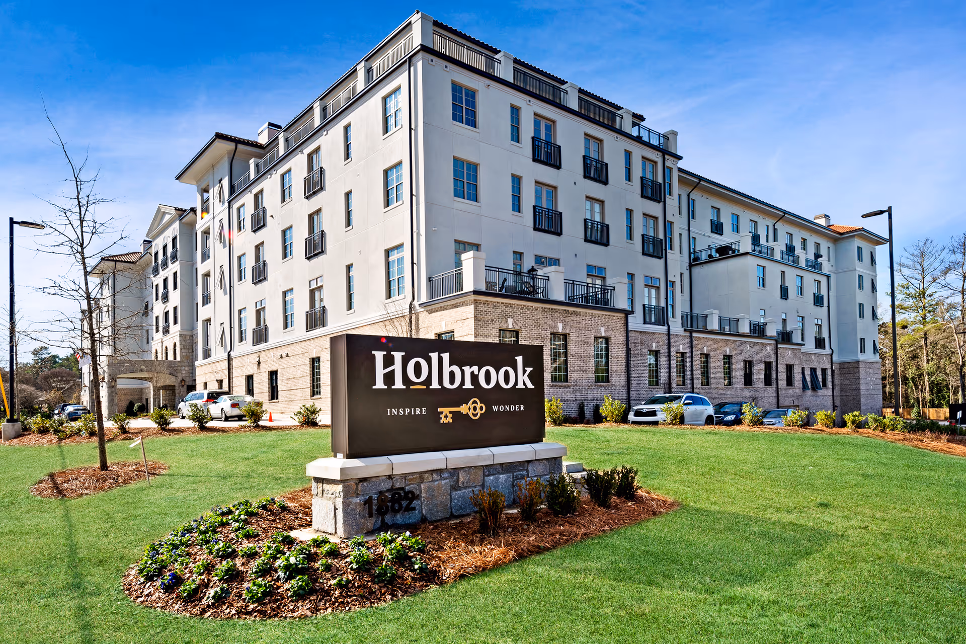 Front exterior of the Holbrook Decatur senior living building with a large Holbrook sign on a landscaped lawn.