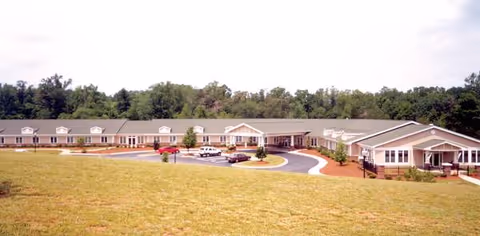 Woodridge senior living facility exterior shows parked cars and a circular driveway.