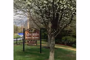 Exterior view of Mrs Bushs Personal Care Homes sign in front of the building.