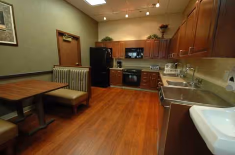 Cozy communal kitchen and dining area with wooden cabinets and stainless appliances.