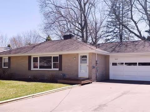 Single-story brick facility with a front entrance, steps, and an attached garage.
