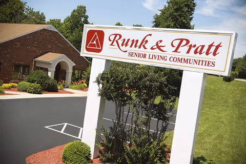 Exterior view of Runk and Pratt Senior Living entrance with a large sign and landscaping