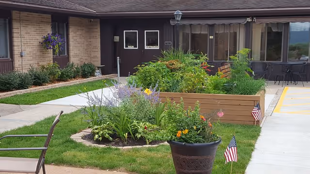 Front exterior of St Michael's Assisted Living with doors and landscaped garden beds.
