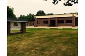 Exterior view of Keosauqua Health Care Center, brick building with sign on a grassy lawn.