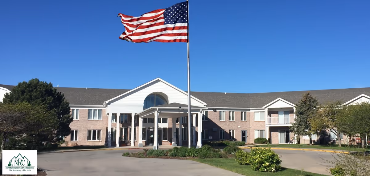 Exterior view of The Residency at Northfield Retirement Communities with an American flag in front.