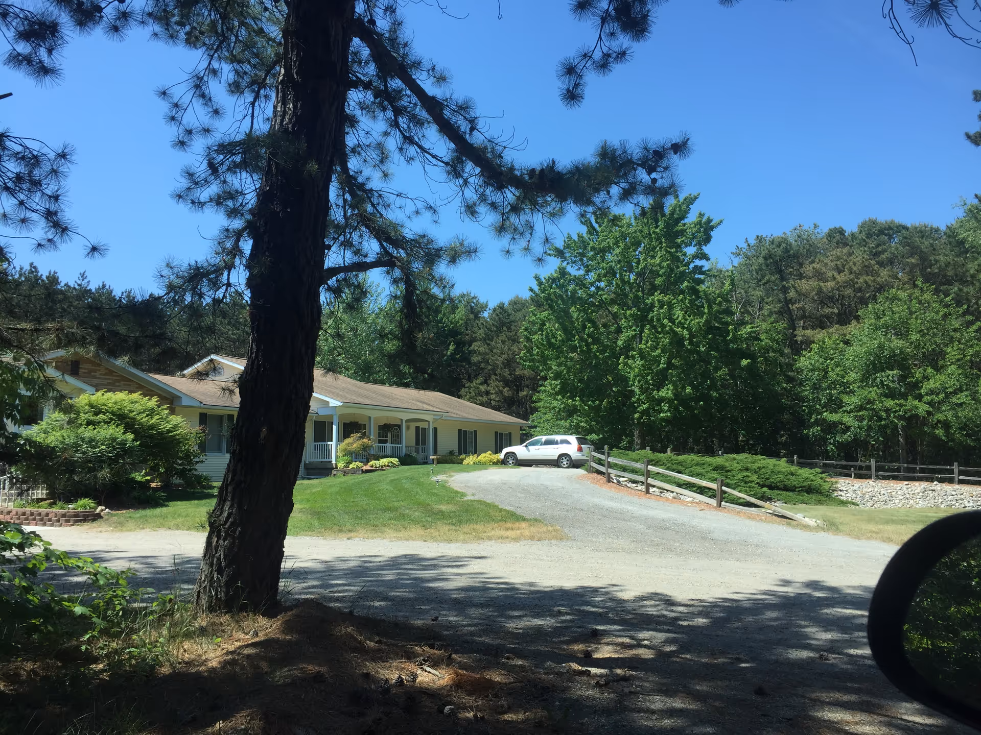 A view of the Agape Home Assisted Living facility surrounded by trees and greenery.