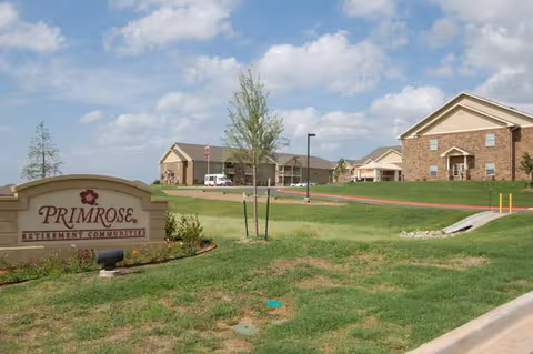 Exterior view of Primrose Retirement Community of Stillwater with sign and entrance.