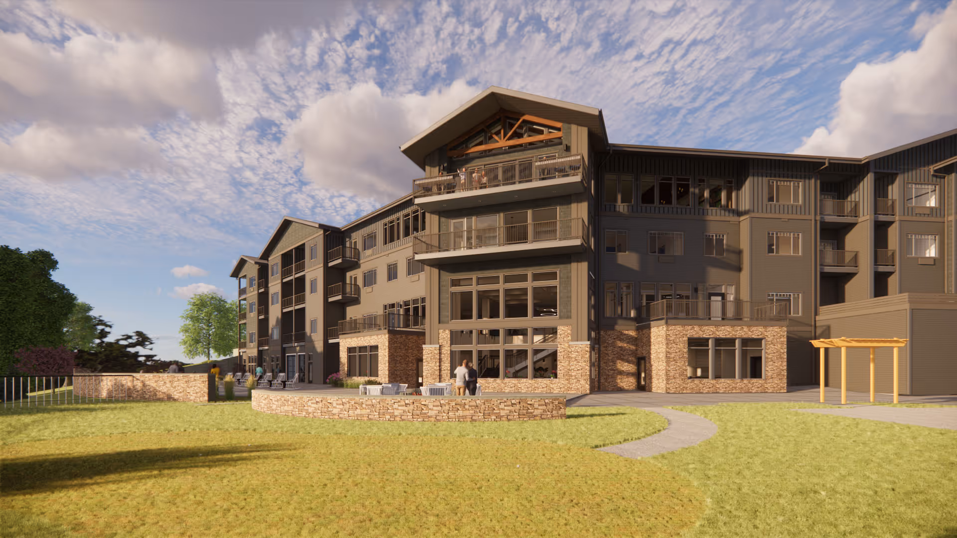 Exterior view of a multi-story retirement community building with balconies, large windows, and a stone facade on the lower level. The building is surrounded by a grassy lawn and a paved walkway, with a partly cloudy sky overhead.