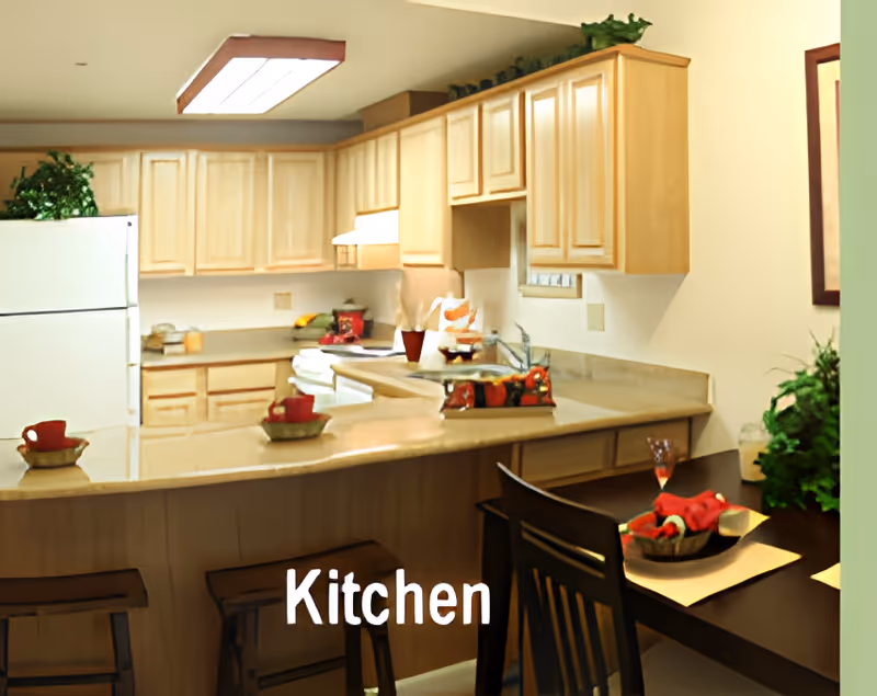 Bright kitchen with light wood cabinets, a curved breakfast bar with stools and a small dining table, with a 'Kitchen' label overlay.