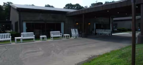 Exterior view of Elderwood Village at Vestal entrance with benches and chairs.