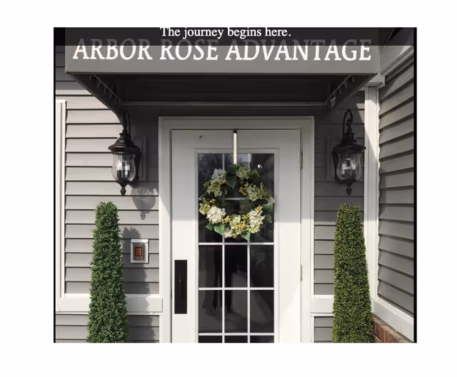 A front entrance of Arbor Rose of Charleston with wreath, lanterns, and trimmed shrubs.