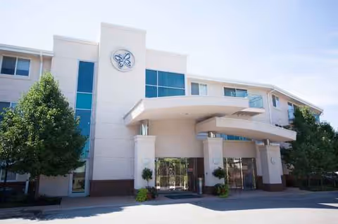 Front view of Garden Villas of Lenexa, a modern senior living facility with curved entrance canopies.