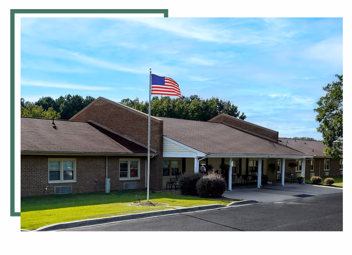 A single-story senior living facility with flagpole and covered entrance.
