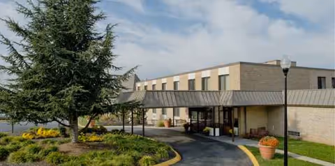 Future Care Old Court facility exterior with covered entrance and landscaped surroundings.