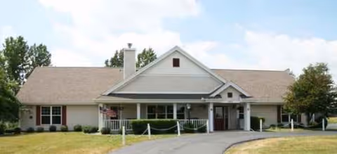 Front view of a single-story senior living facility with a covered entrance and driveway.