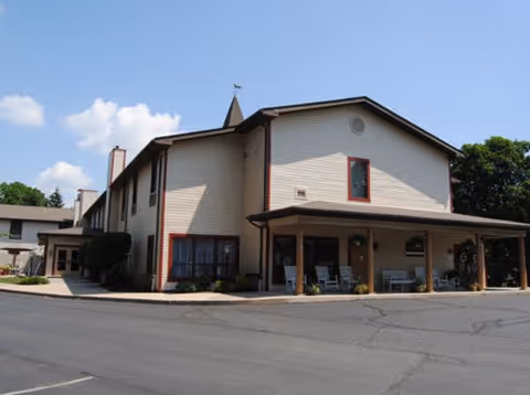 Exterior view of Above and Beyond at the Knights, a beige two-story senior living facility.