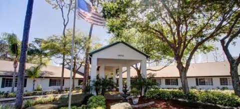 A Brookdale Tarpon Springs exterior view showing a single-story building with entrance canopy and landscaping.