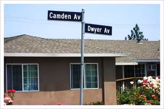 A single-story senior living facility building with Camden Ave and Dwyer Ave street signs.