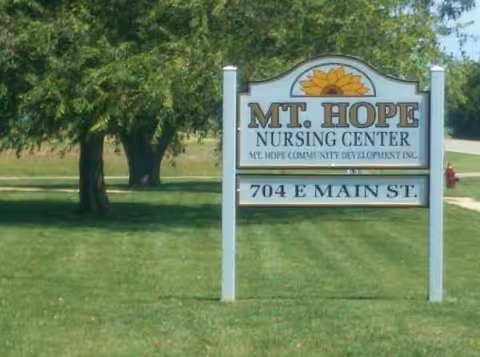 Outdoor lawn with Mount Hope Nursing Center sign and surrounding trees.