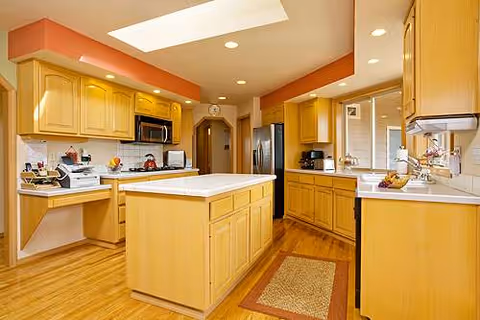 Bright, spacious kitchen with an island, wooden cabinets, and stainless appliances.