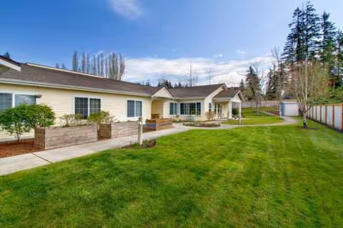 Orchard Pointe by Cogir exterior with green lawn and paved walkway.