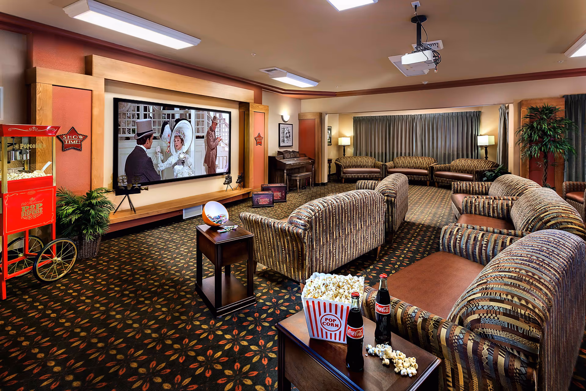 A cozy movie room featuring comfortable seating, a large screen displaying a classic film, a popcorn machine, and refreshments including popcorn and Coca-Cola.