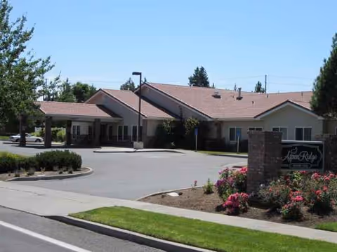 Exterior view of Aspen Ridge Memory Care entrance with parking and landscaped grounds.