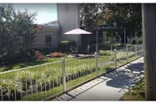 Exterior view of Windsor Park Rehab & Nursing Center with walkway, railing, and umbrella.