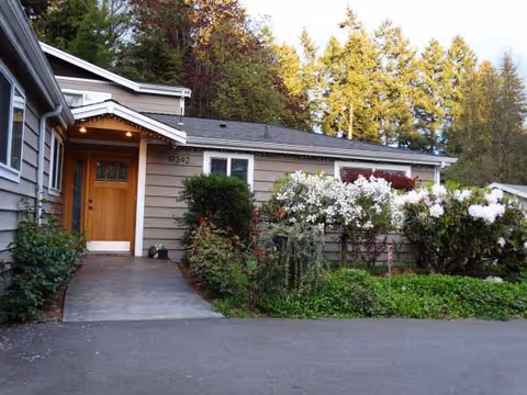 Front exterior view of a single-story senior care building with path and landscaping.