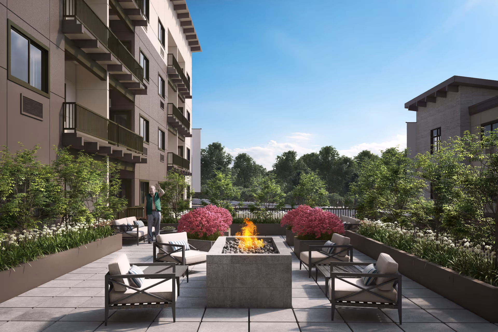 Outdoor courtyard with a central fire pit, lounge chairs, planters and apartment balconies in the background.