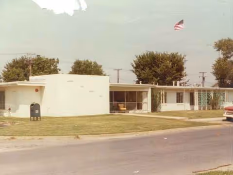 Exterior view of a small medical facility with curved white walls and front entrance.