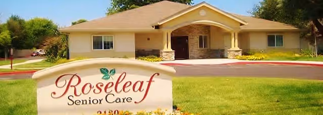 Front entrance of a single-story senior care building with a lawn and a sign reading "Roseleaf Senior Care".