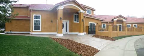 Exterior view of Sungarden Villa I, a tan stucco senior living building with arches.