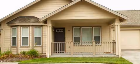Beige exterior of a senior living community with a covered front porch.