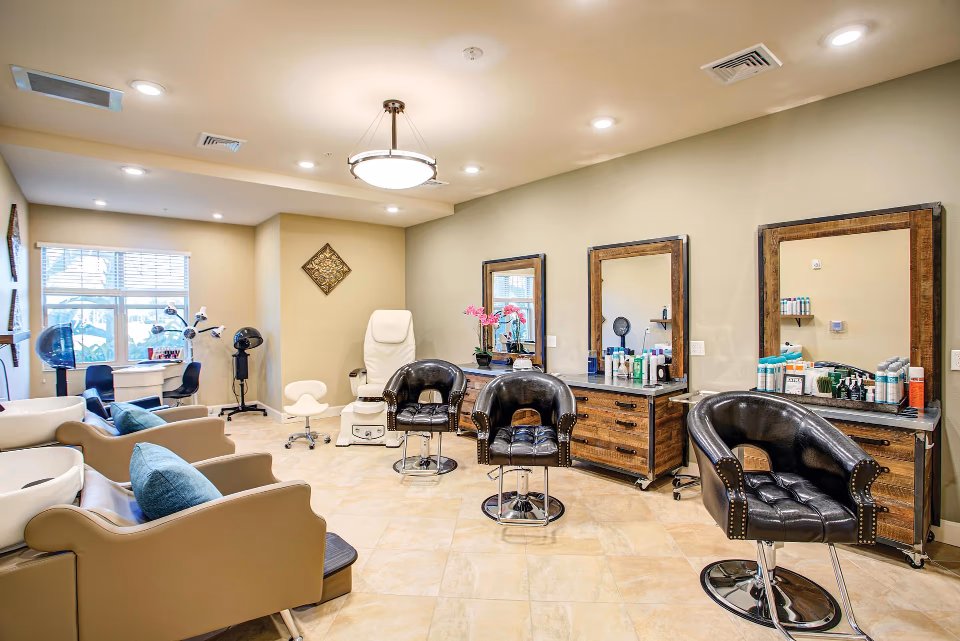 Bright salon-style interior with styling chairs and mirrors, pedicure stations and a seating area.