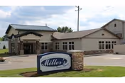 Miller's Merry Manor front exterior with driveway, sign, and entryway.
