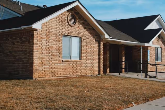 Brick exterior of a senior living facility with front entrance ramp.