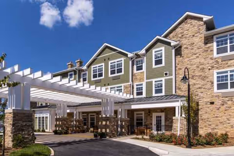 Exterior view of Brightview Great Falls entrance with stone columns and a covered walkway.