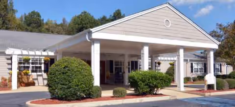 Front view of Brookdale Newnan senior living facility entrance with shrubs.